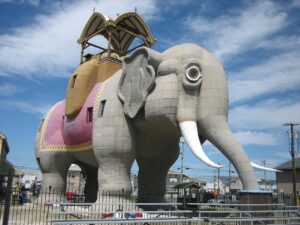 A six-story historic wooden elephant structure with ornate saddle detailing, functioning as a novelty museum near the Atlantic coast.