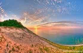 Iconic dune bluff towering above a secluded Lake Michigan beach with panoramic blue horizons.