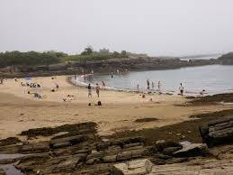 A scenic view of Kettle Cove at Cape Elizabeth, with rocky coastline and waves crashing on the shore.