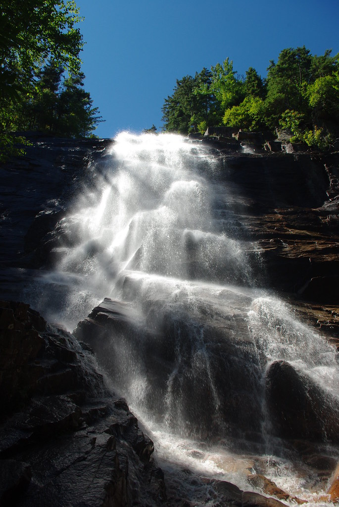 Arethusa Falls in New Hampshire with a dramatic 200-foot drop, surrounded by lush greenery in the White Mountains.