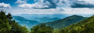 Hiker walking along an easy trail in the Smoky Mountains, surrounded by vibrant trees and beautiful natural scenery."